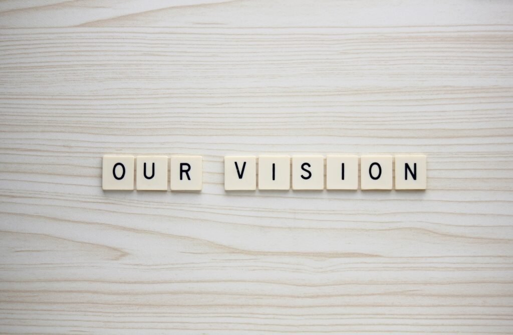 Our Vision letter tiles on a wood grain background